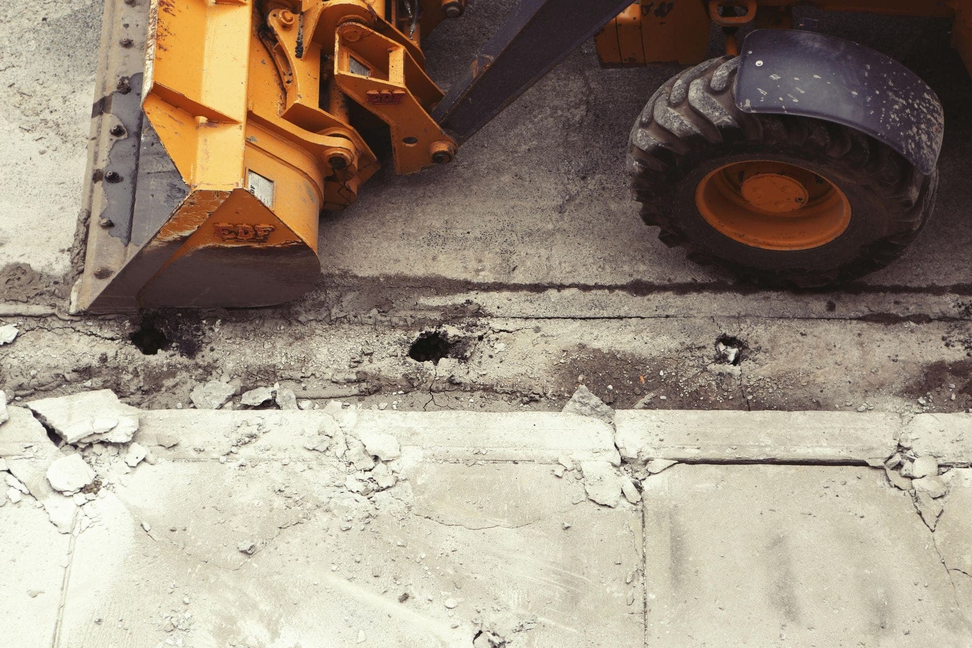 Loader breaking street concrete during right-of-way utility work