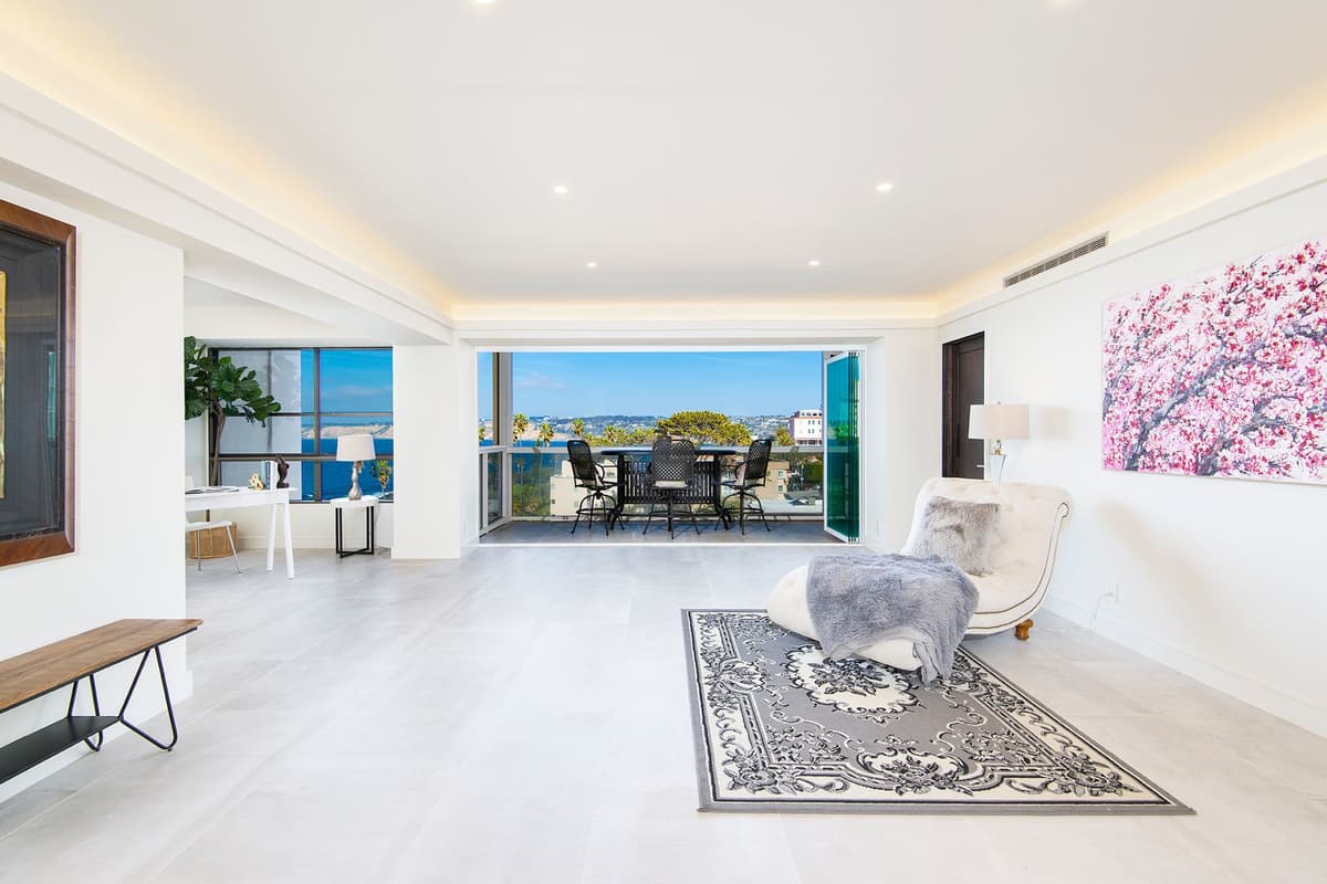 Remodeled living room opening to an ocean-view balcony, by Nucave