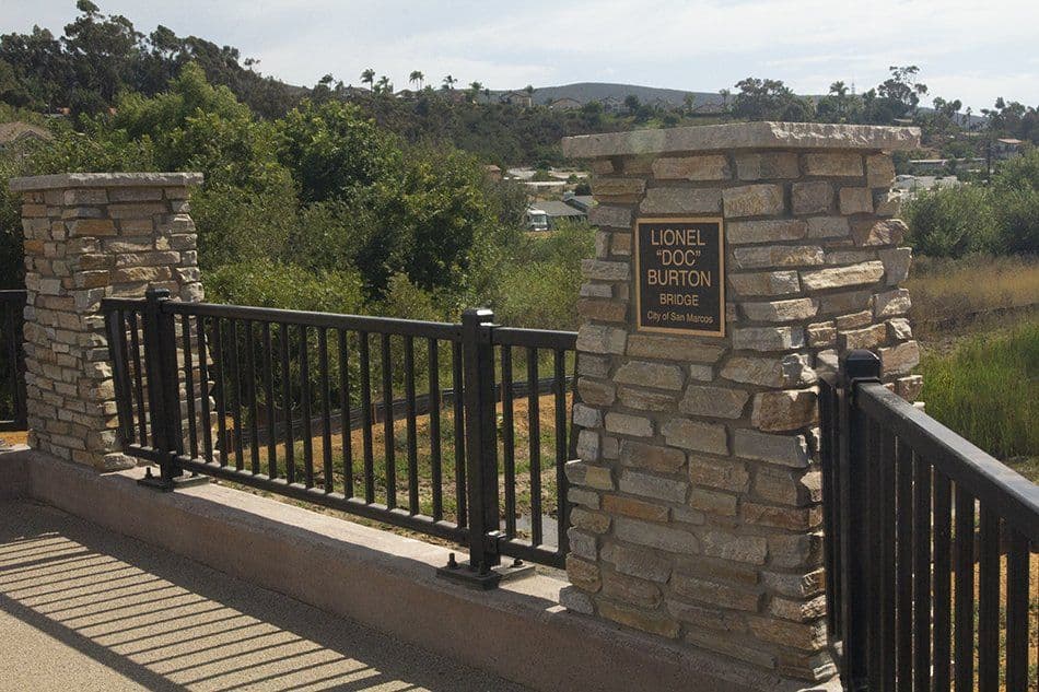 Lionel Doc Burton Bridge dedication plaque mounted on a stone pillar.
