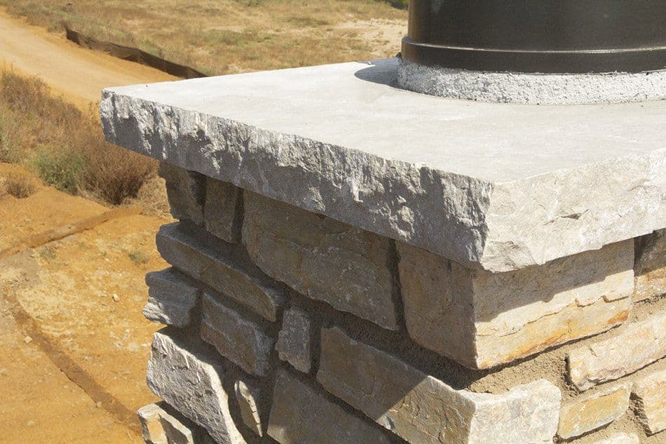 Chiseled stone cap and lamppost base on a bridge pillar.