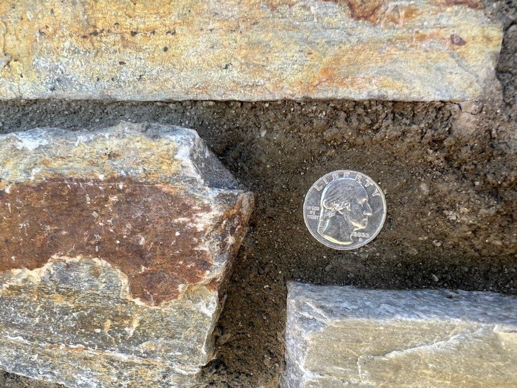 Quarter coin shown for scale inside a deep stone mortar joint.