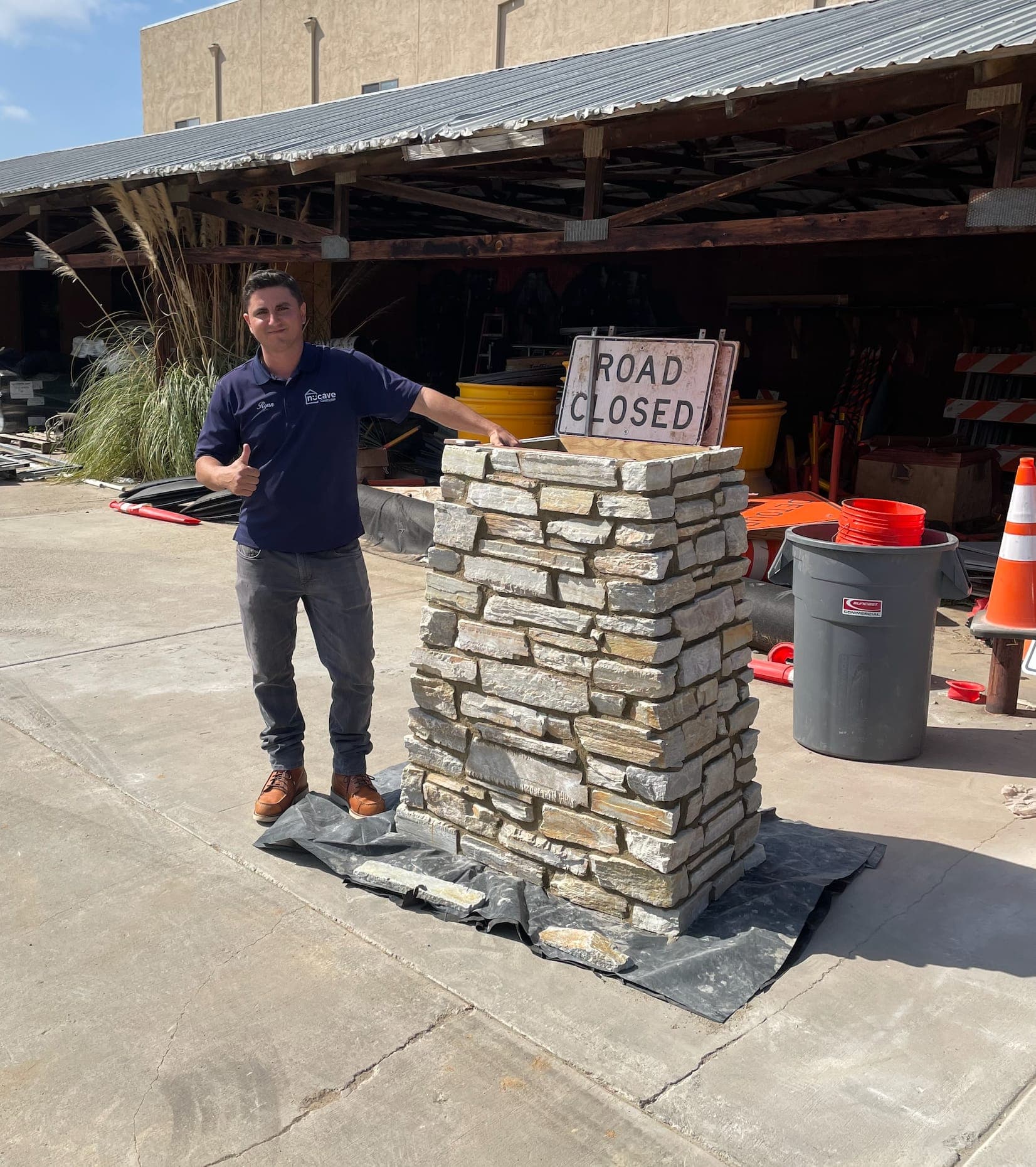 Nucave's Ryan giving a thumbs up beside a stone pillar mockup.