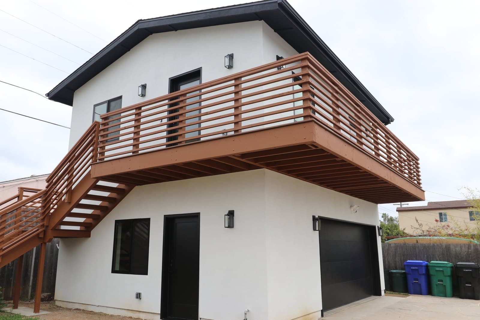 Bay Ho ADU above a garage with wraparound wood balcony, built by Nucave
